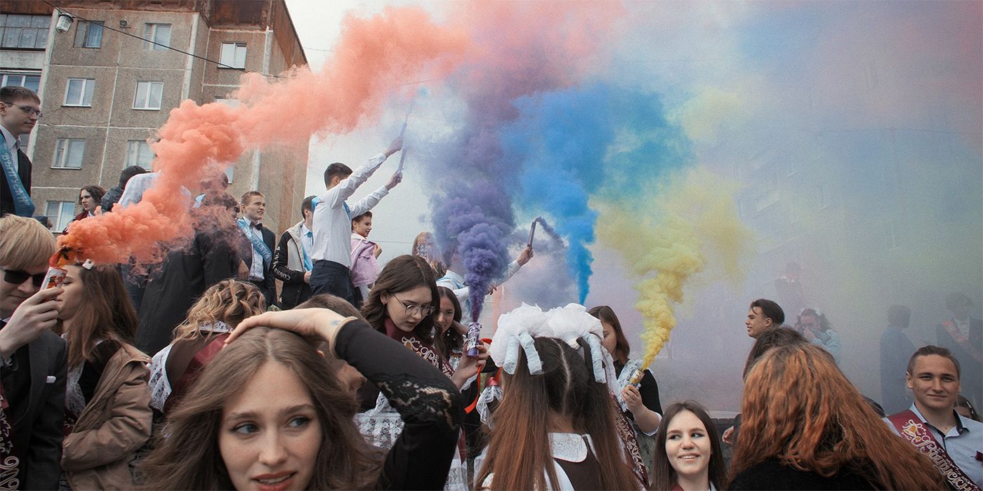 A bunch of students celebrating with colorful smoke in the air in Mr. Nobody Against Putin