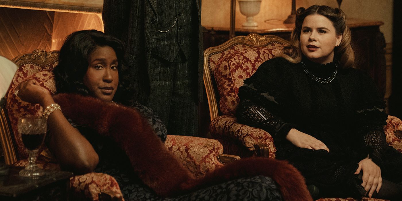 Naomi Ekperigin and Jessie Ennis in period dresses sitting in armchairs in Mythic Quest