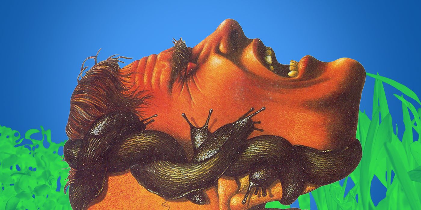 A man&rsquo;s horizontal screaming face, wrapped in slugs, against a blue sky and grassy background.