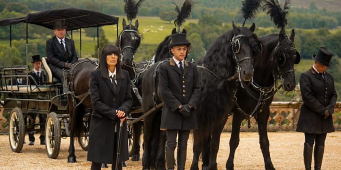 Claudia Winkleman stood in front of a carrigae and funeral procession in The Traitors UK.