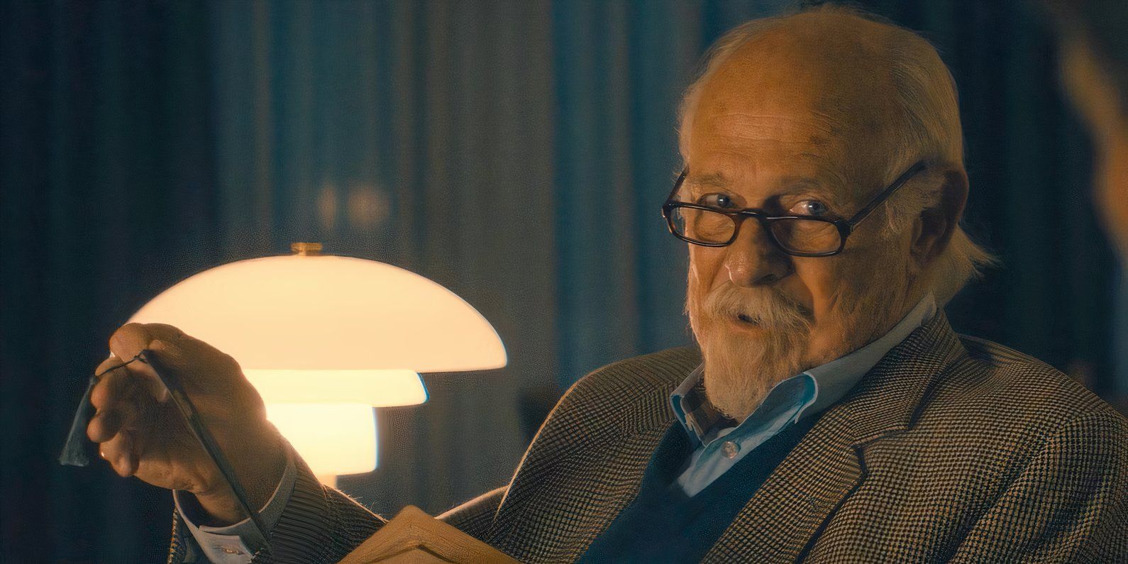 Gerald McRaney as Cal&rsquo;s father Kane wearing glasses and reading a book by a lamp in Paradise.