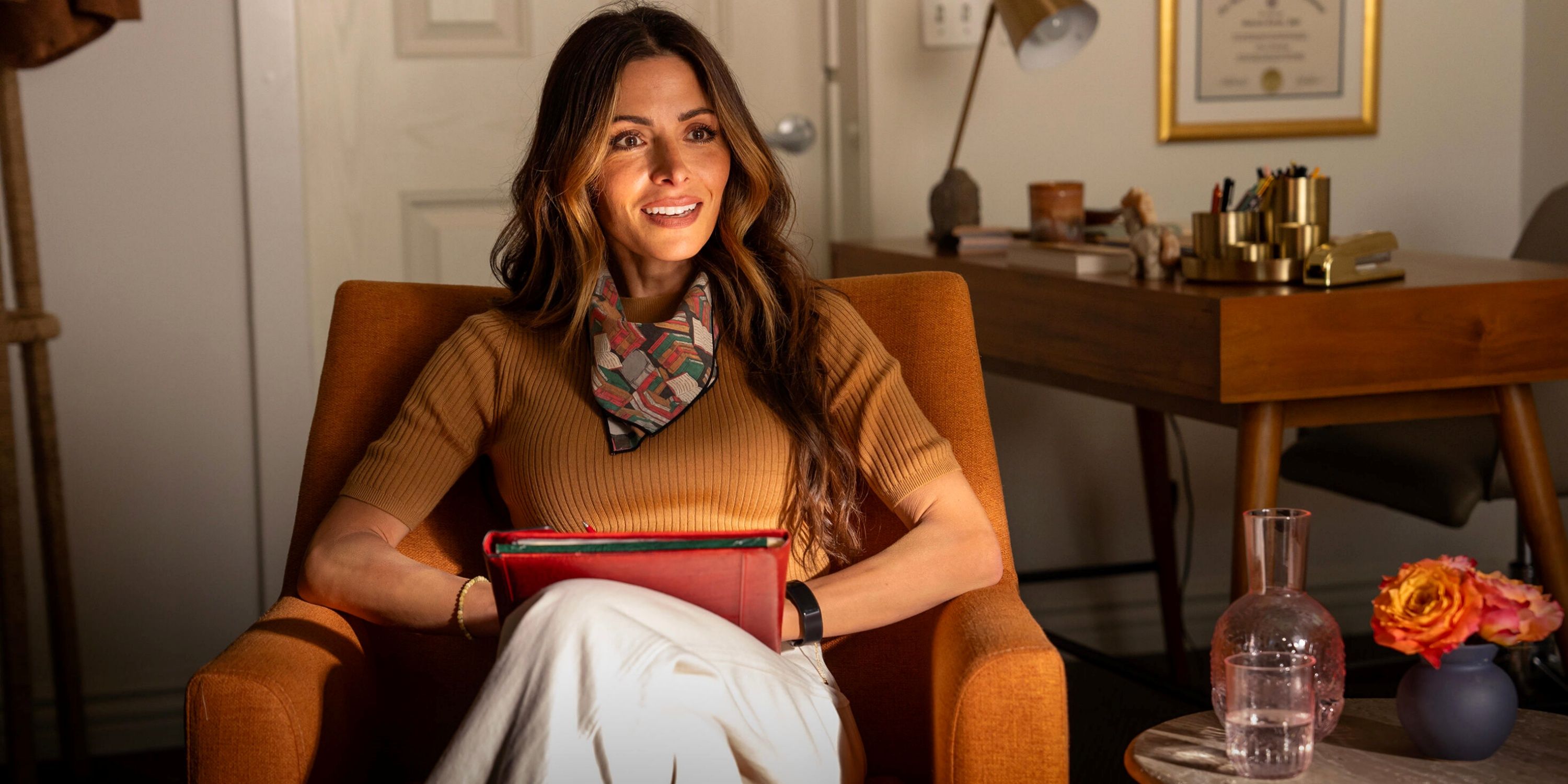 Sarah Shahi as Dr. Gabriela Torabi sitting in a chair during a therapy session in Paradise