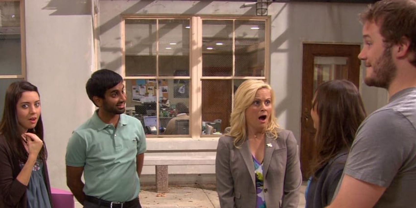 April (Aubrey Plaza), Tom (Aziz Ansari), Leslie (Amy Poehler), Ann (Rashida Jones), and Andy (Chris Pratt) talking in the courtyard in Parks and Rec