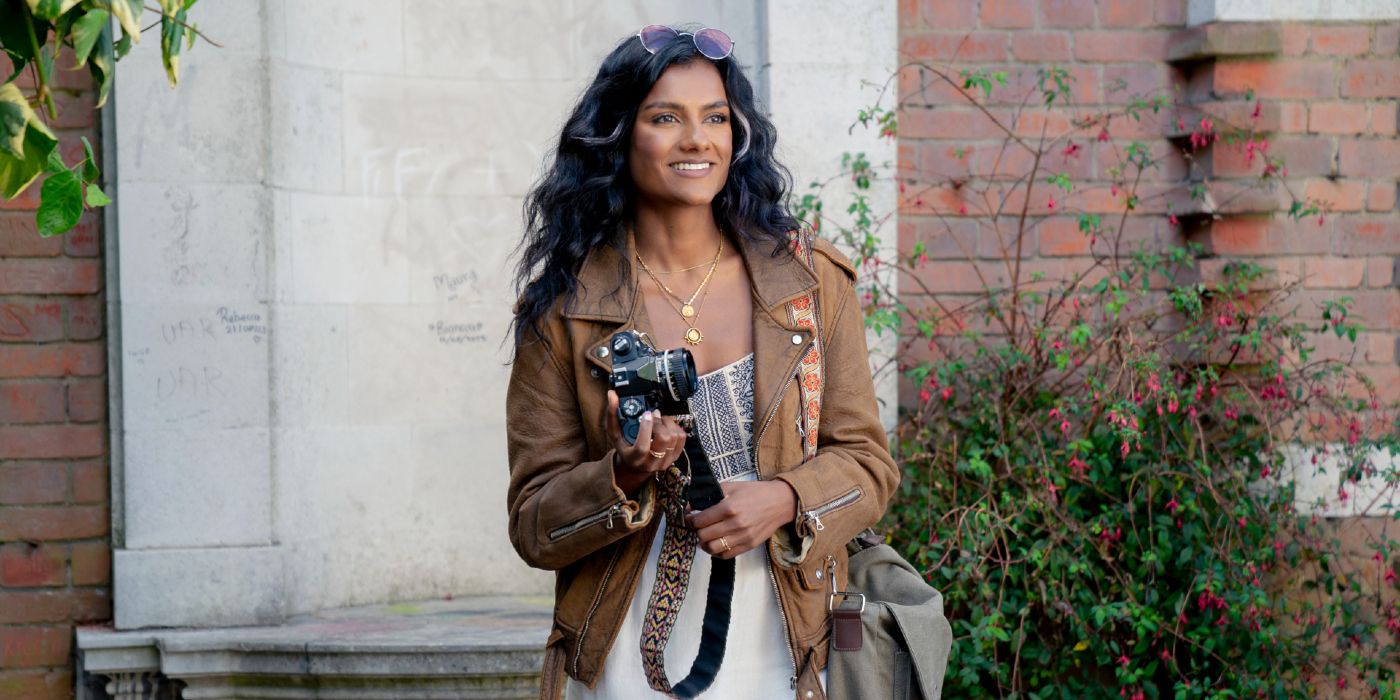 Ashley Simone as Pia holding her camera and smiling in Picture This