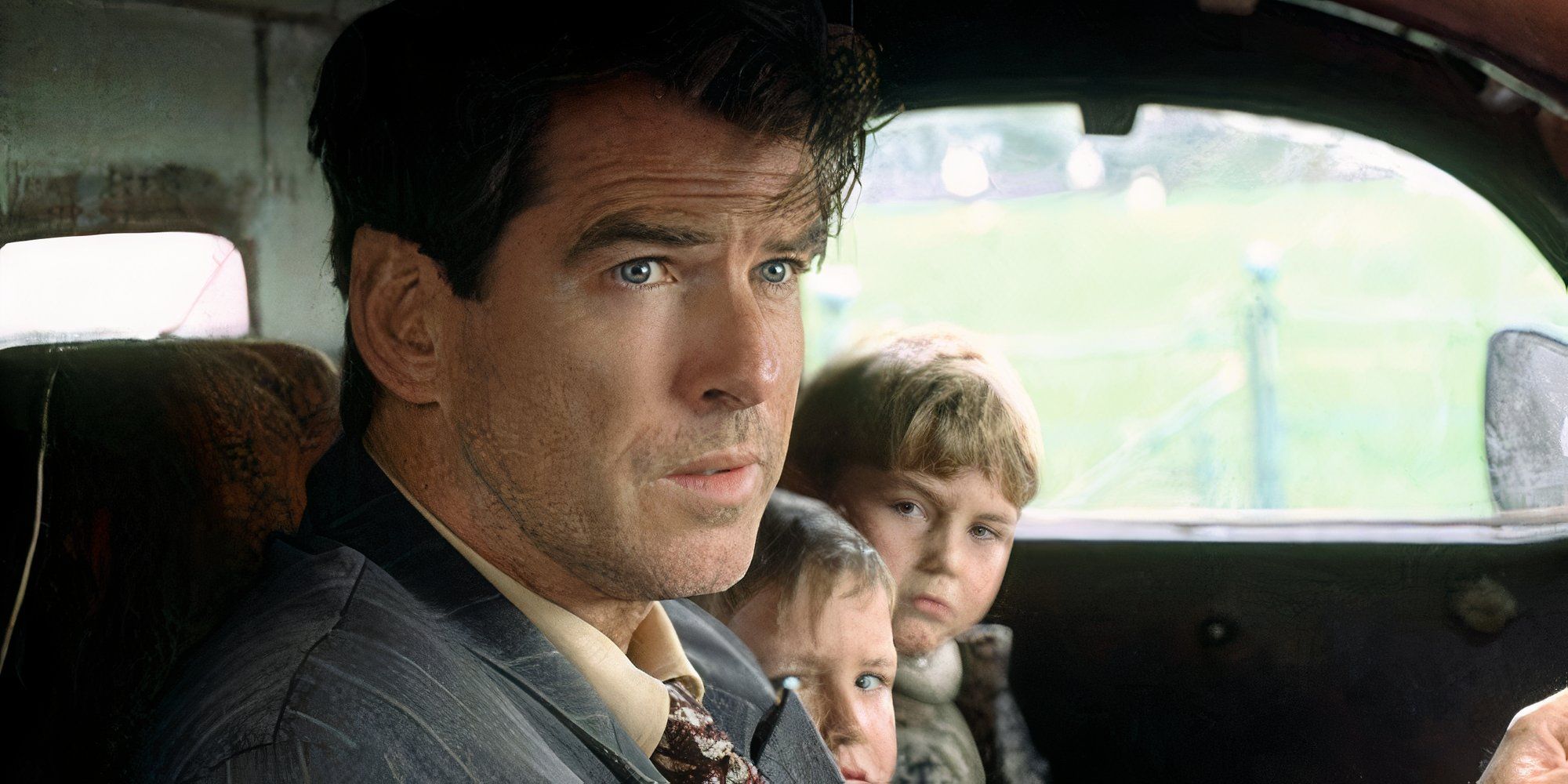 Pierce Brosnan sitting in a car with two children sitting next to him in Evelyn (2002)