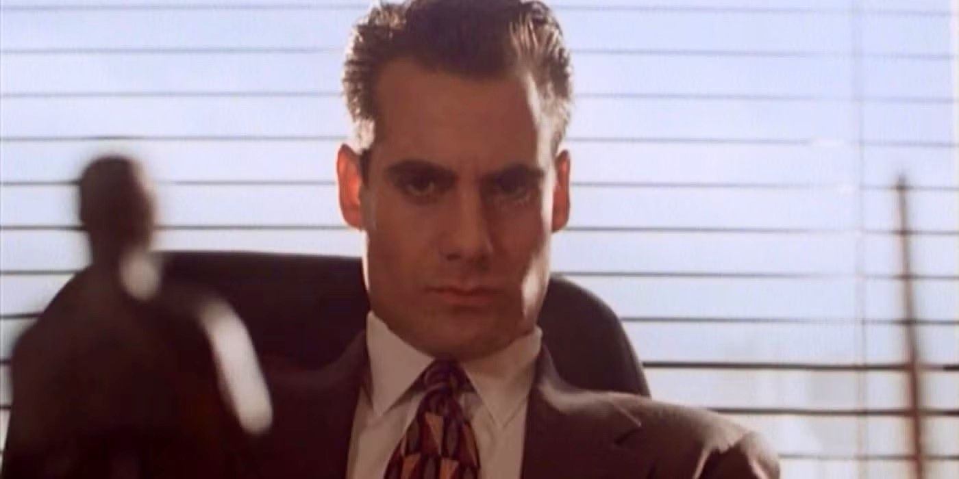 Adrian Pasdar in a business suit sits back in a chair in an office, looking serious in Profit.