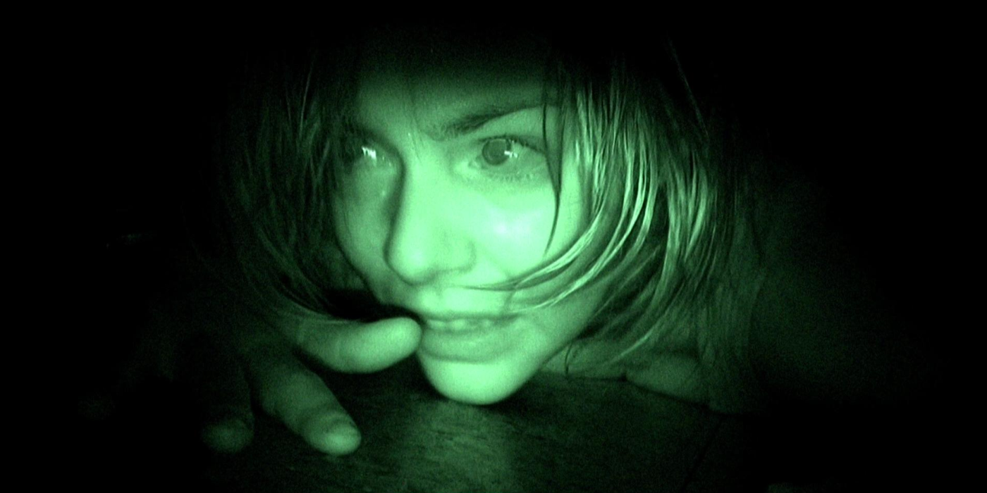 A woman lies on the floor in night vision in REC (2007)