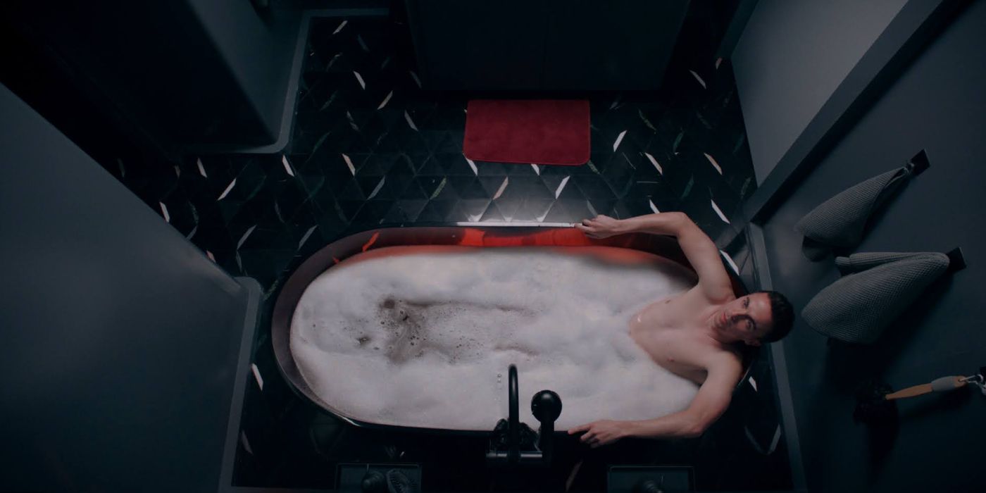 Frankie Muniz as Renner, lying in a bathtub in a gray bathroom in Renner.