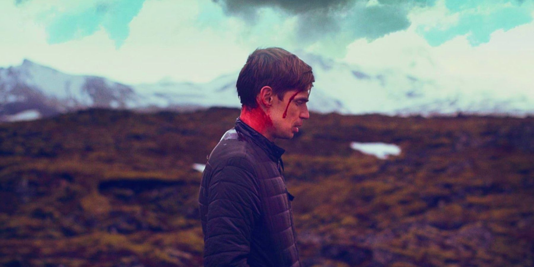 Bj?rn Stefánsson as Gunnar, walking alongside a snowy mountain with blood on his face and neck in Rift.