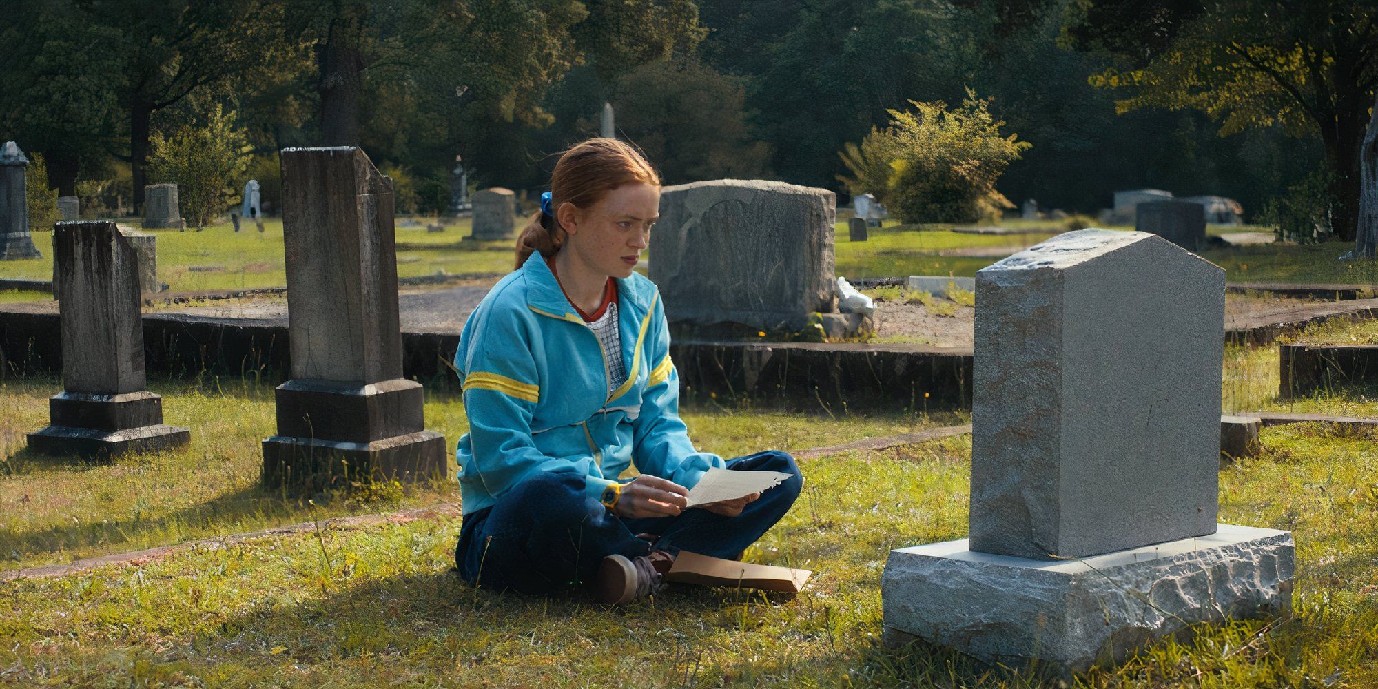 Sadie Sink as Max in Stranger Things sitting down in front of Billy&rsquo;s grave