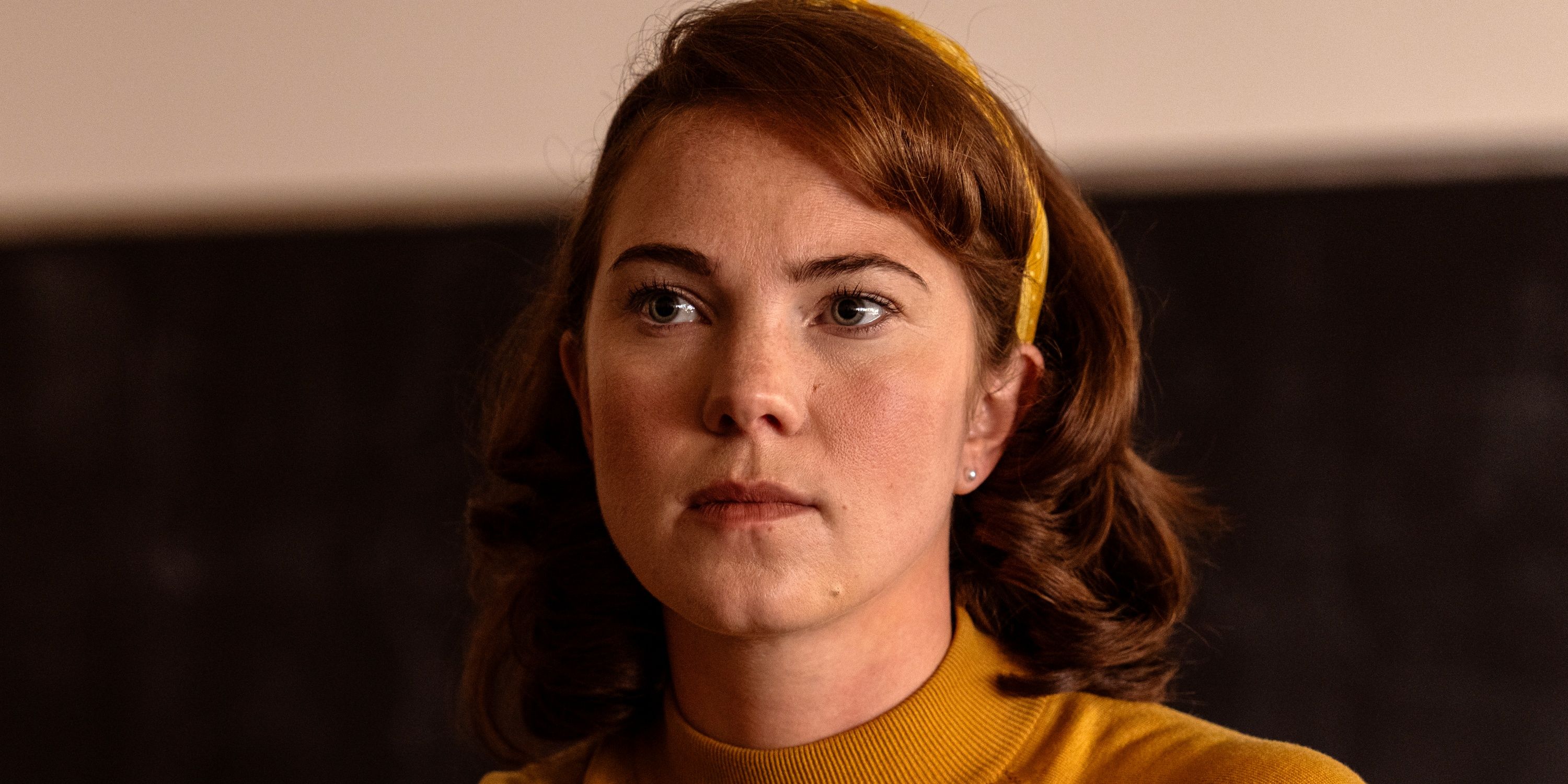 Jess Gabor as Janet in a mustard shirt and headband in Season 2 of School Spirits