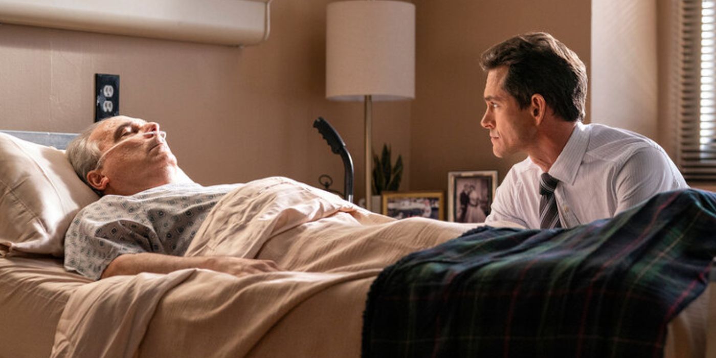 Barry Kolman as William Price in a hospital bed with Hugh Dancy as Nolan Price sitting at his bedside in 'Law & Order'