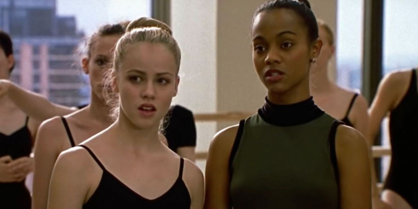 Amanda Schull and Zoe Saldana as Jody and Eva wearing a black and grey leotard in a ballet studio in 'Center Stage'