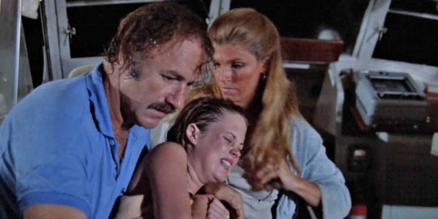 Gene Hackman, Melanie Griffith, and Jennifer Warren as Harry, Delly, and Paul on a boat wearing a blue shirt in &lsquo;Night Moves&rsquo;