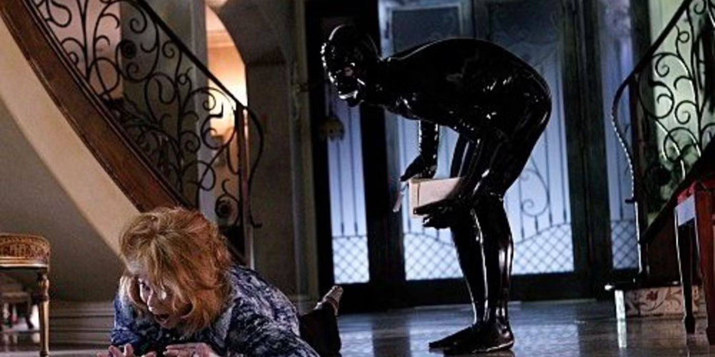 A figure in a black latex bodysuit with a zipper mouth lurks after a woman in CSI episode Sqweegel.