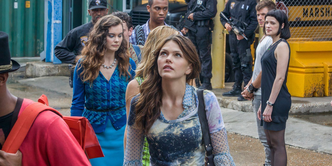 Emery looking up and smilling while others watch her in the show Star Crossed.