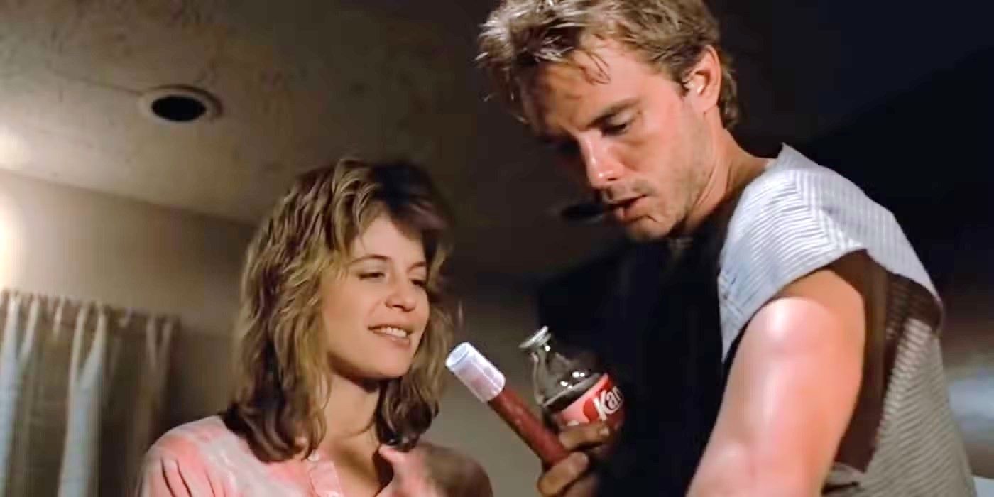 Linda Hamilton as Sarah Connor smiles and stands next to Michael Biehn as Kyle Reese in The Terminator.