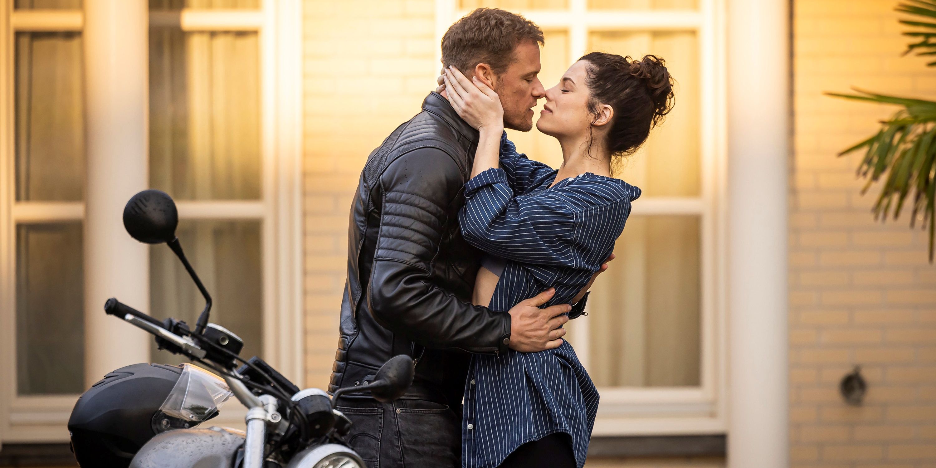 Sam Heughan as Danny holding the waist of Jessica De Gouw as Becka before they kiss in The Couple Next Door