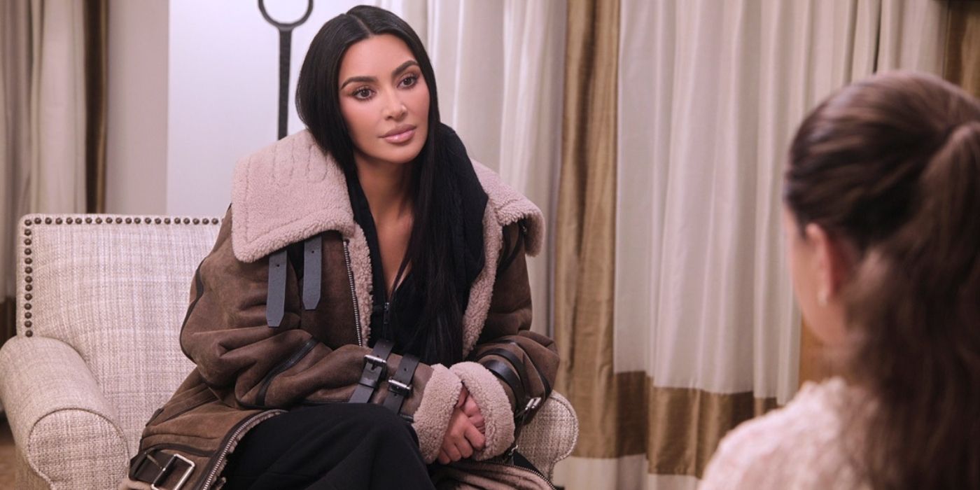 Kim Kardashians sits on the couch on &lsquo;The Kardashians.'