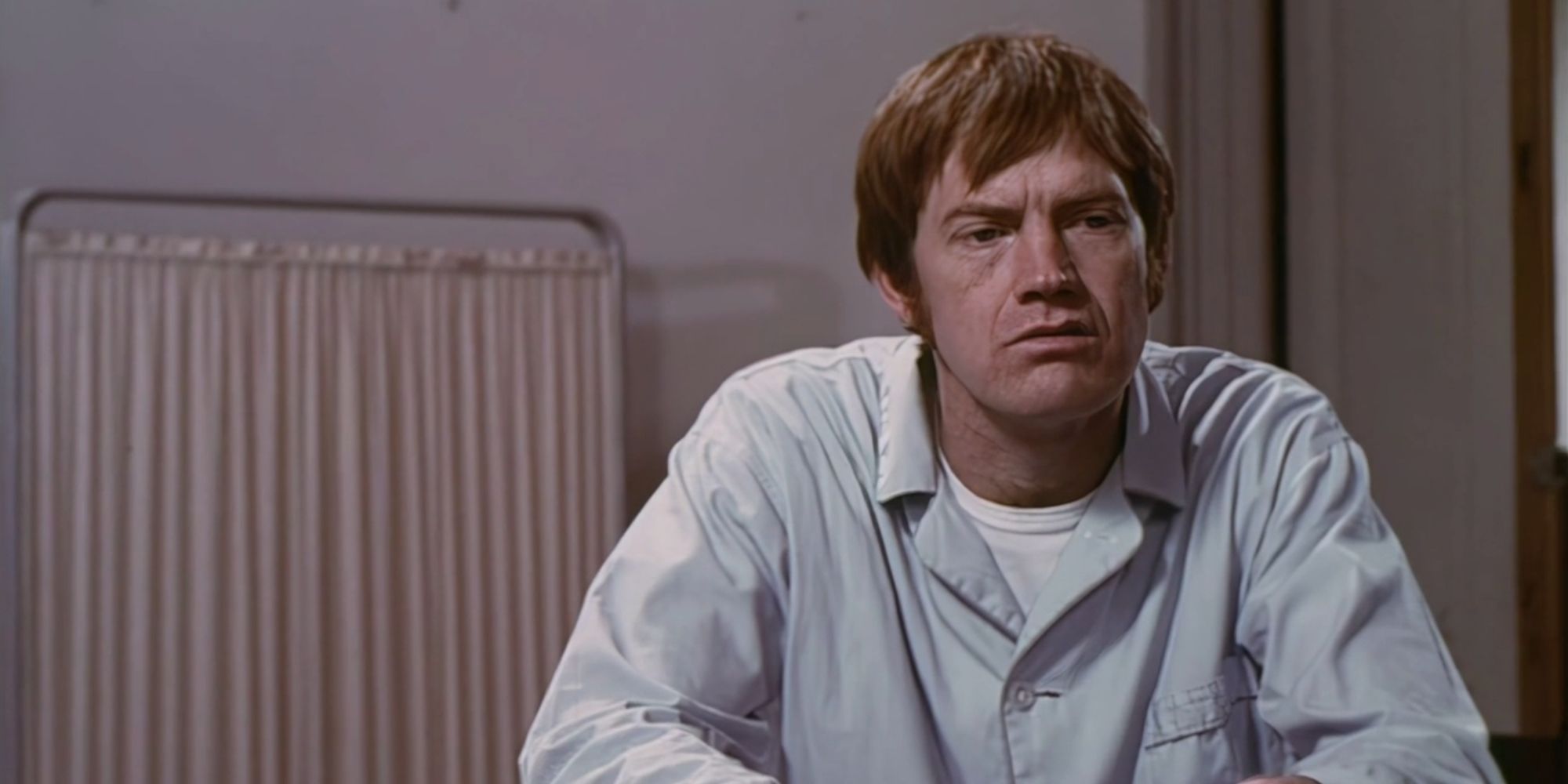 Miles (Ronny Cox) sits on a hospital bed in The Mind Snatchers / The Happiness Cage