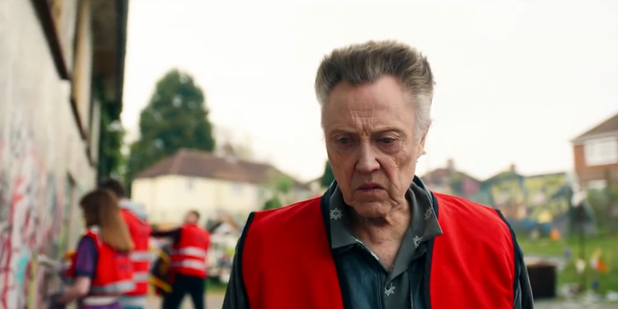 Christopher Walken in a reflective vest looking toward a graffiti-covered wall in &lsquo;The Outlaws&rsquo;