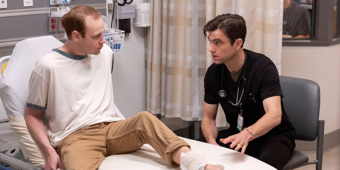 Dr. Langdon (Patrick Ball) talking with Terrance (Coby Bird) in a hospital room in The Pitt