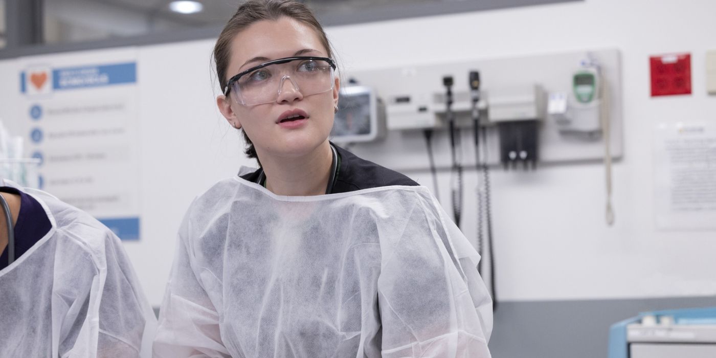 Dr. Santos (Isa Briones) stands in goggles and a white covering in a hospital room in 'The Pitt'