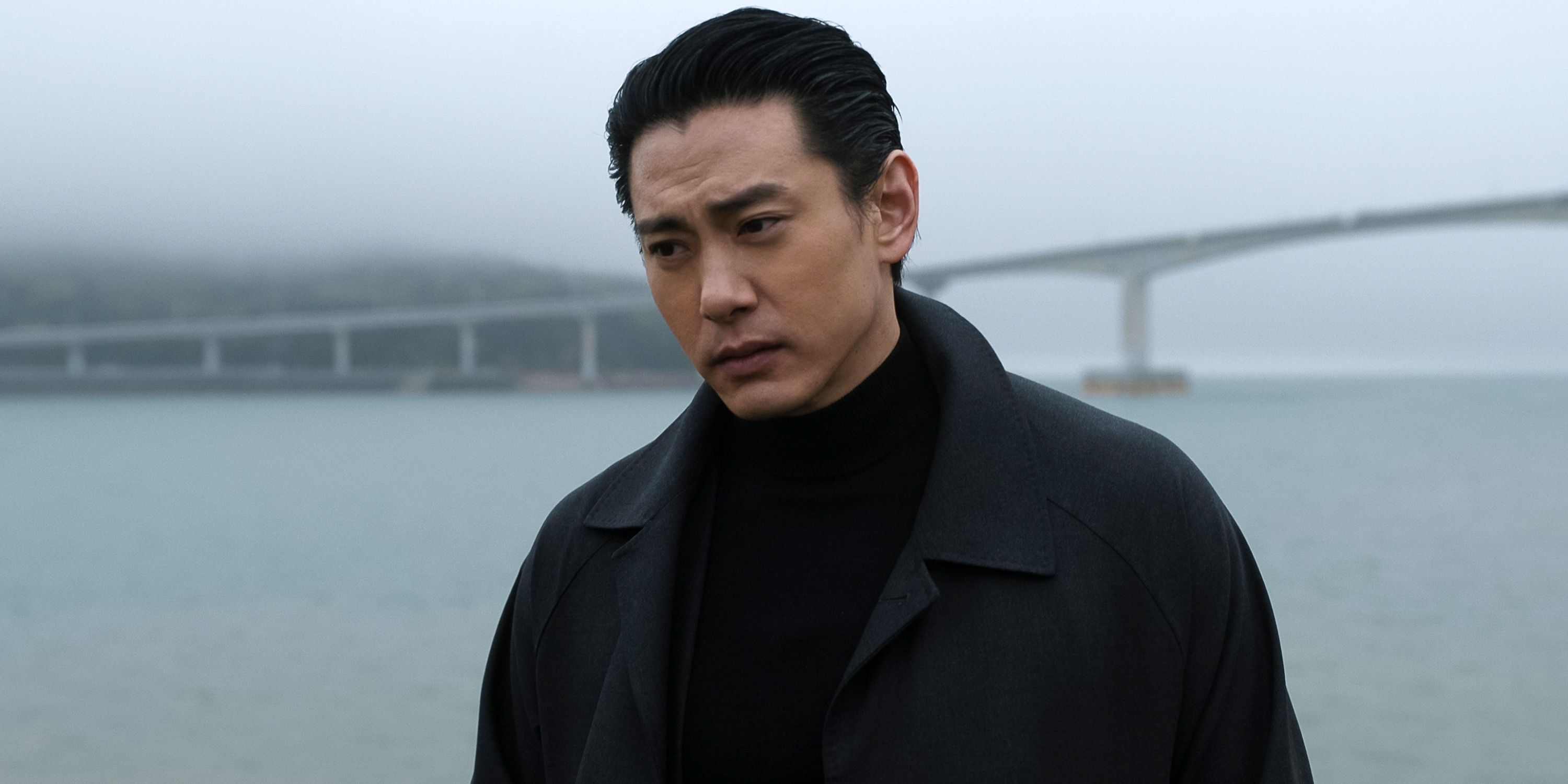 Teo Yoo as Jang Kyun looking forlorn in front of a bridge over a body of water in Season 2 of The Recruit