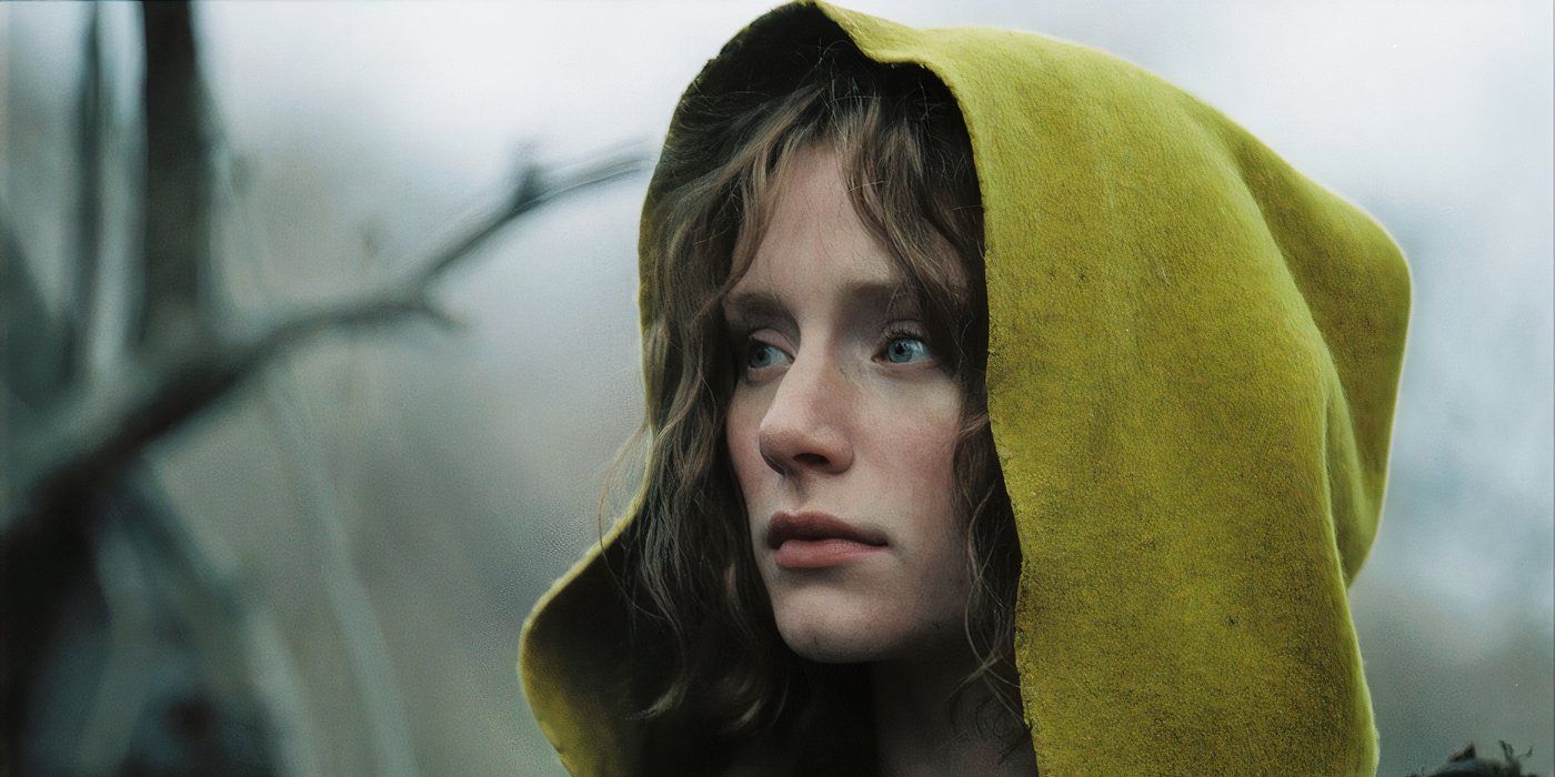 Bryce Dallas Howard as Ivy in a yellow, hooded cloak in the woods looking to her right in The Village.