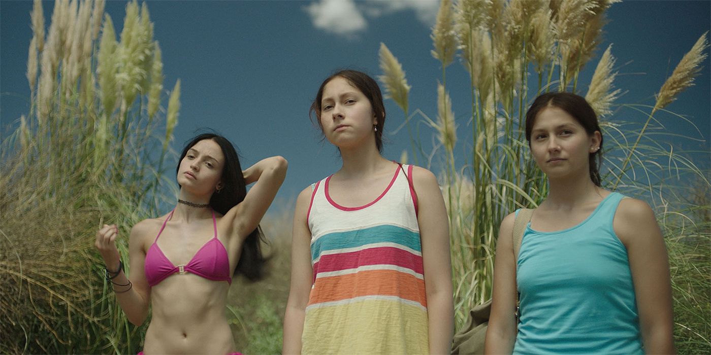 Dolores Oliverio in a pink bikini standing next to two girls in The Virgin of Quarry Lake