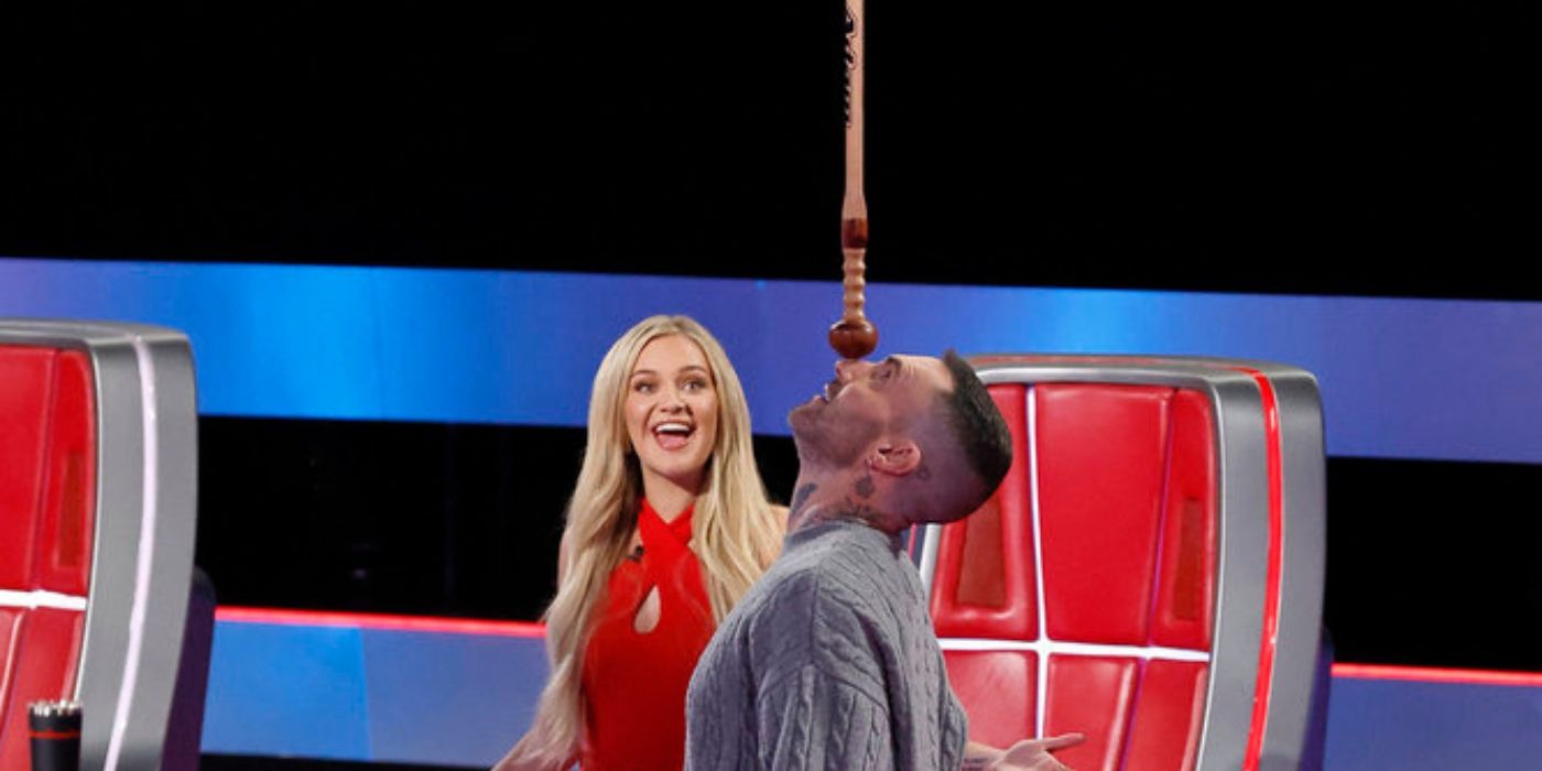 Kelsea Ballerini watches Adam Levine play with the sword on 'The Voice' Season 27.