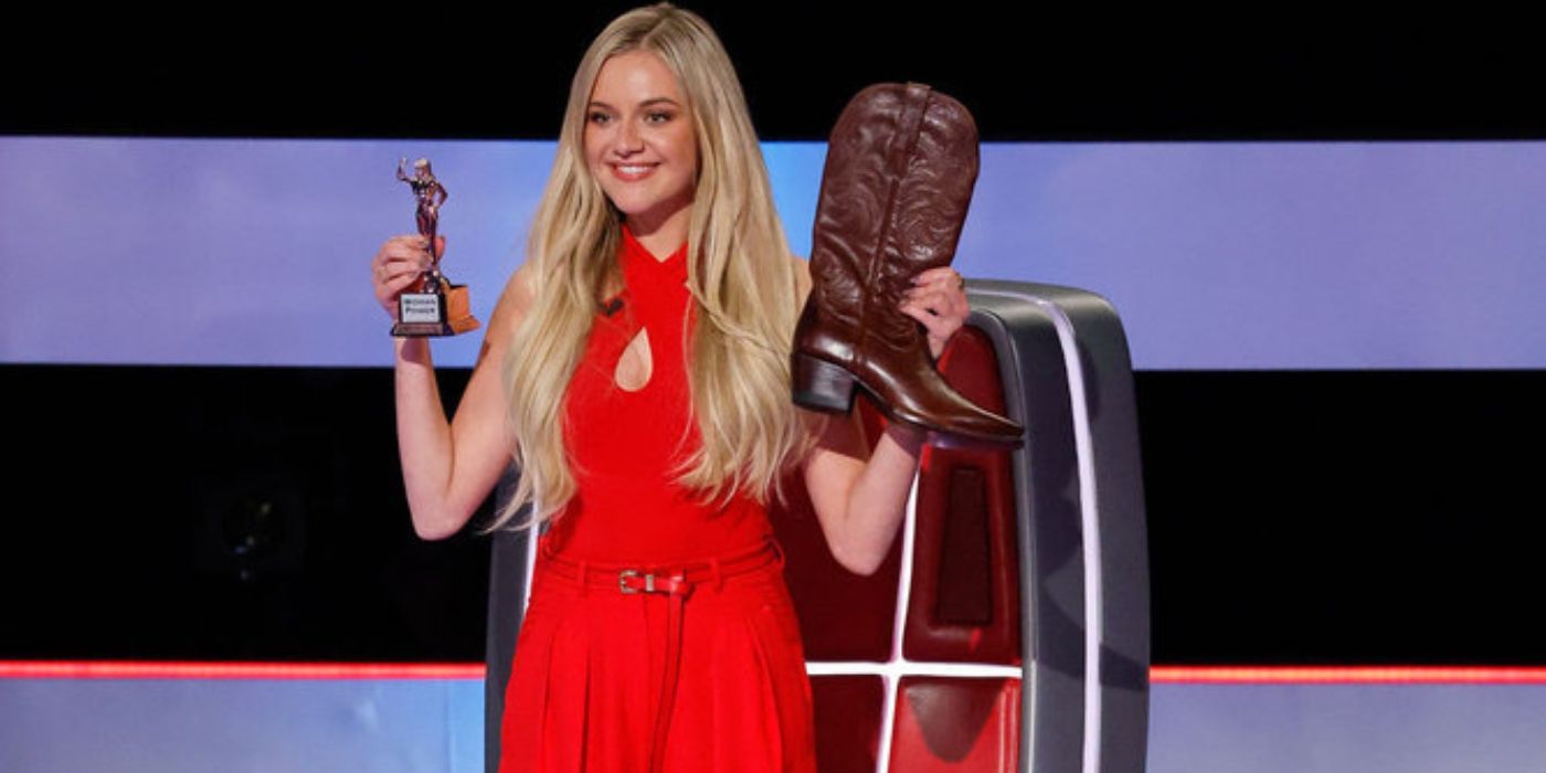 Kelsea Ballerini holds her boots and a trophy on 'The Voice' Season 27.