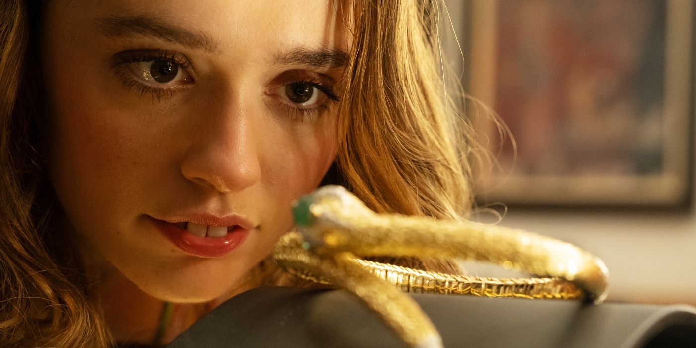 Aimee Lou Wood as Chelsea staring at golden snake necklace in The White Lotus Season 3, Episode 2.
