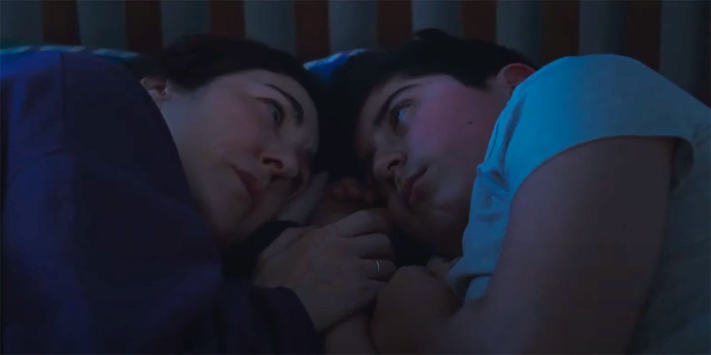 A mother with her son in bed talking to him in Two Women