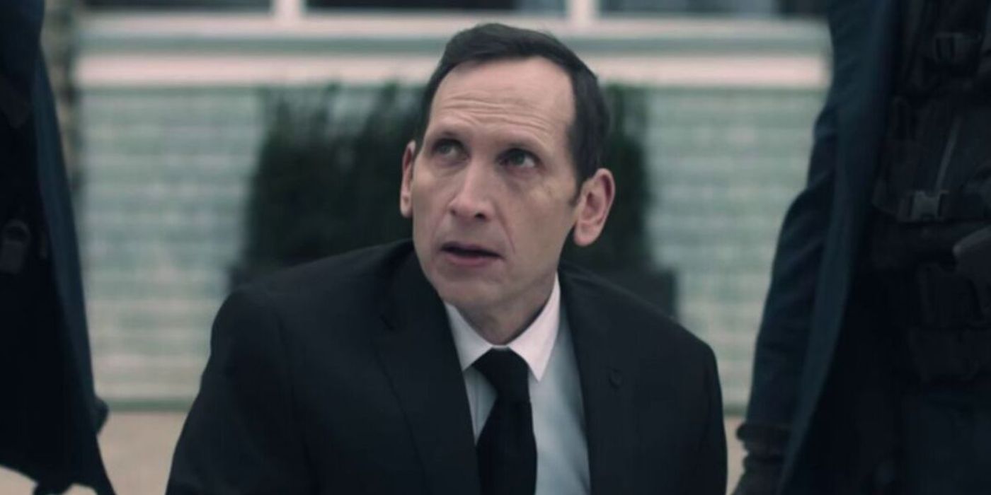 Stephen Kunken as Warren Putnam wearing a suit looking up scared in The Handmaid&rsquo;s Tale.