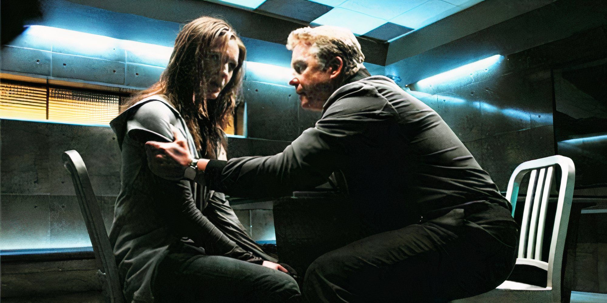William Petersen holding Jessica Ann Collins by the shoulders as they sit next to each other in an interrogation room in CSI episode Living Doll