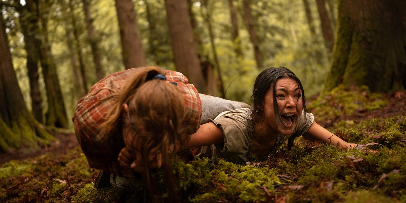 Mari screaming on the ground as Shauna bites her arm in Yellowjackets Season 3