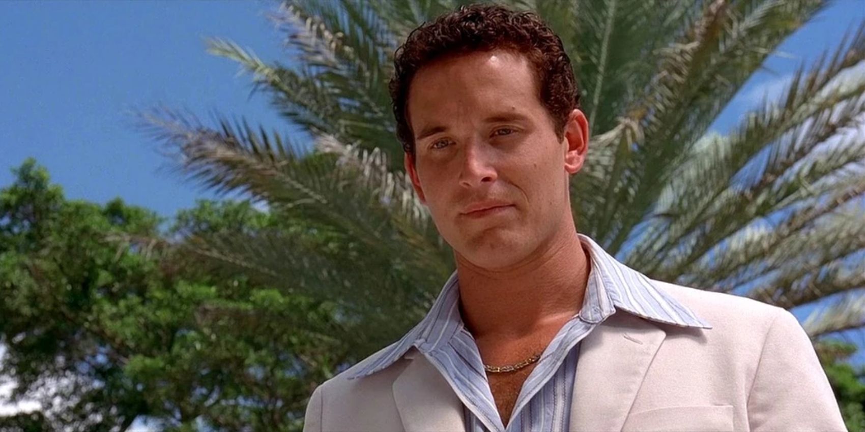 Cole Hauser as Carter Verone, looking down with palm trees behind him in 2 Fast 2 Furious.