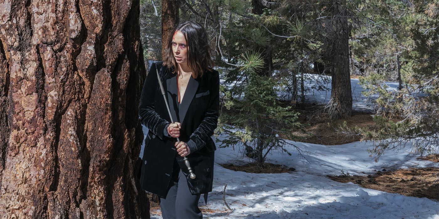 Jennifer Love Hewitt as Maddie standing in the woods with a stick in her hand after running from Doug in 9-1-1