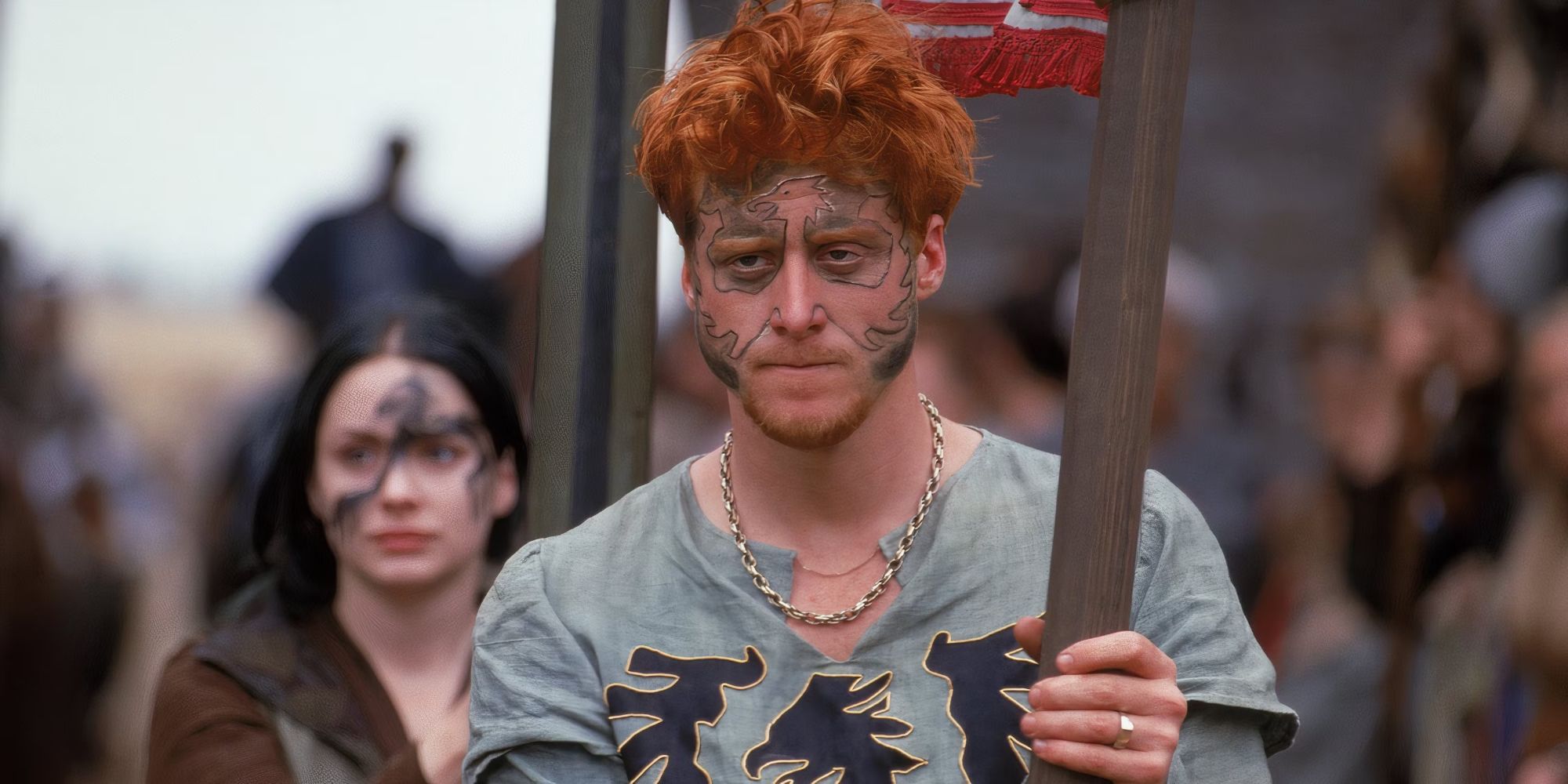 Alan Tudyk as Wat, carrying a flag and wearing face paint in A Knight&rsquo;s Tale.