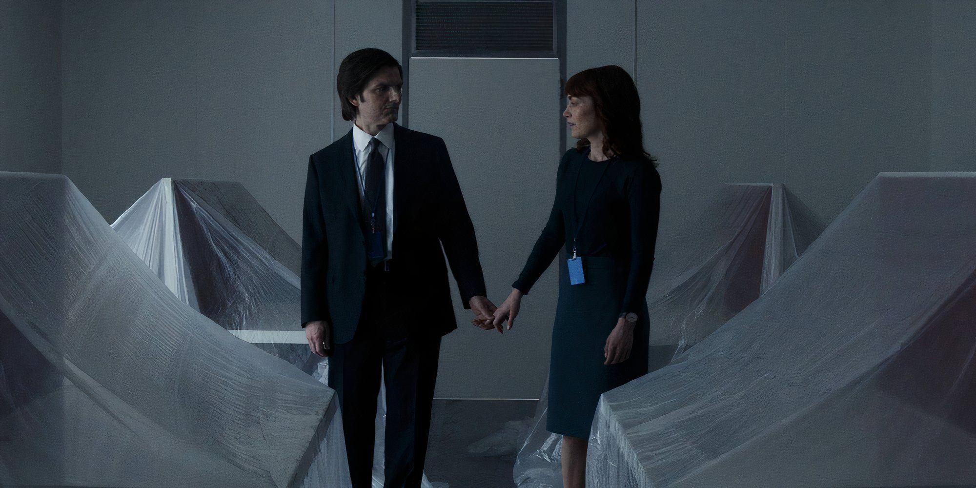 Adam Scott and Britt Lower in Severance as Mark and Helly R. holding hands