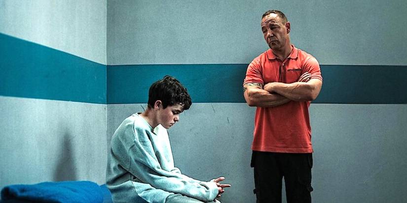 Owen Cooper as Jamie Miller sits in a secure room with Stephen Graham as Eddie Miller nearby in Adolescence.