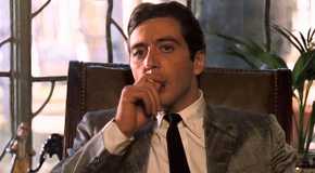 Al Pacino as Michael Corleone sitting in a chair smoking a cigarette in The Godfather: Part II (1974)
