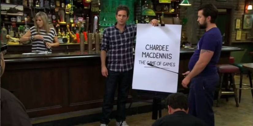 Two men next to a sign that reads "Chardee MacDennis the Game of Games" on It's Always Sunny in Philadelphia.