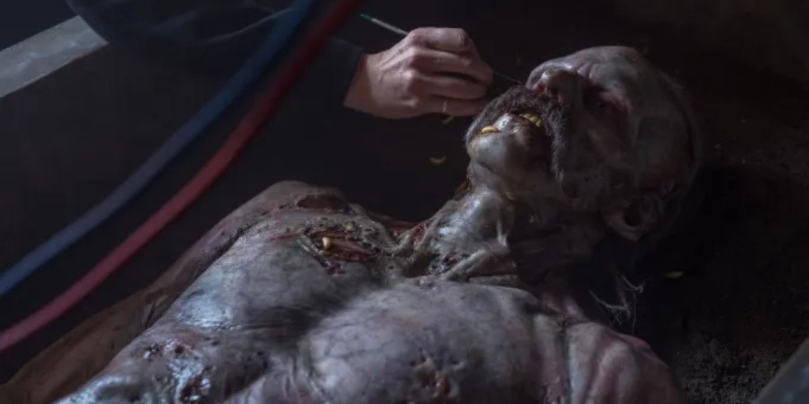 A hand retouching Bill Skarsgård&rsquo;s Orlok makeup as he lies down on the set of Nosferatu