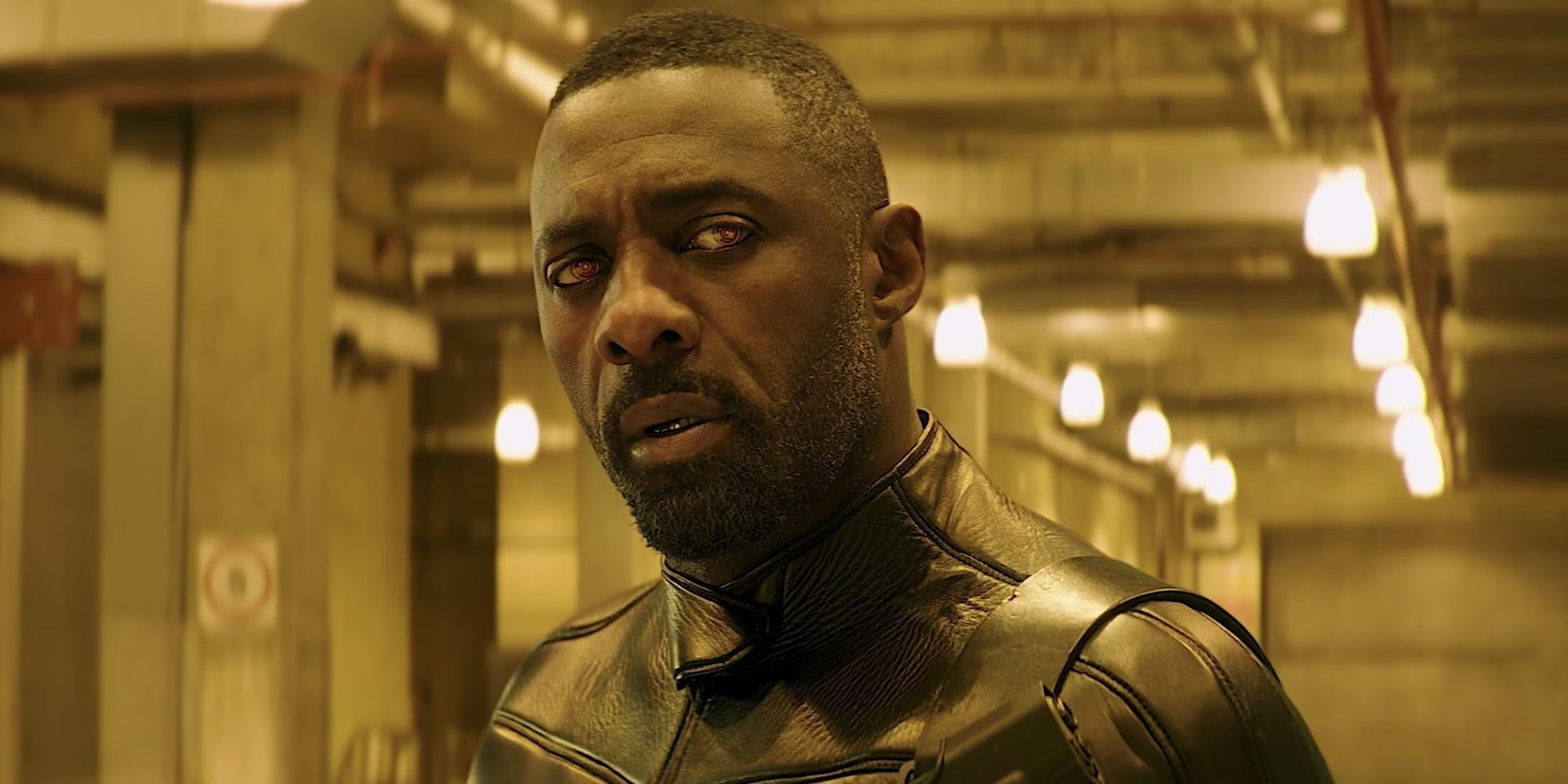 Idris Elba as Brixton in yellow lights looks at something off-screen in Fast &amp; Furious Presents Hobbs &amp; Shaw