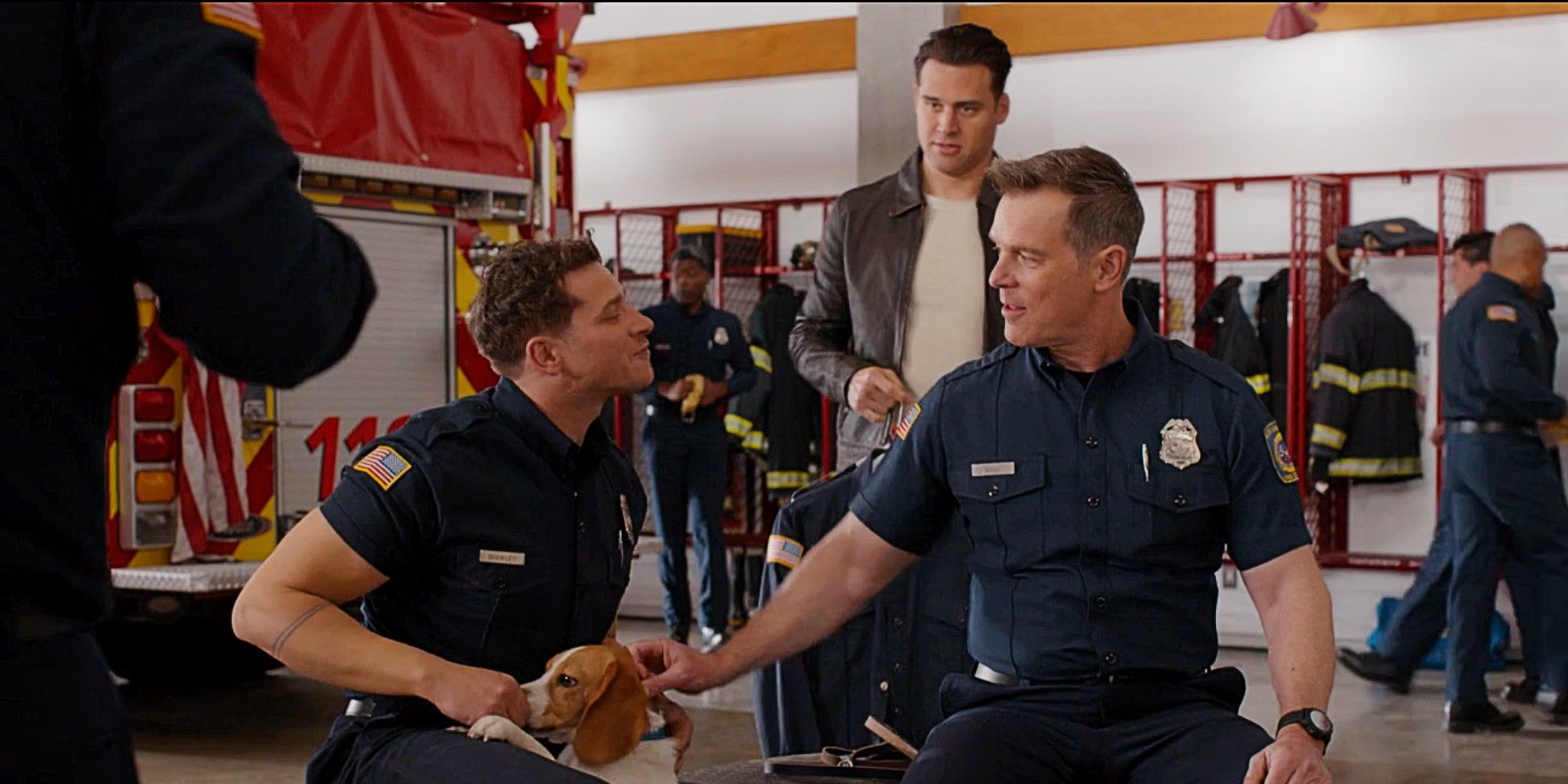 Buck and Bobby playing with a puppy in the fire station while Eddie stands behind them looking annoyed in 9-1-1 Season 8