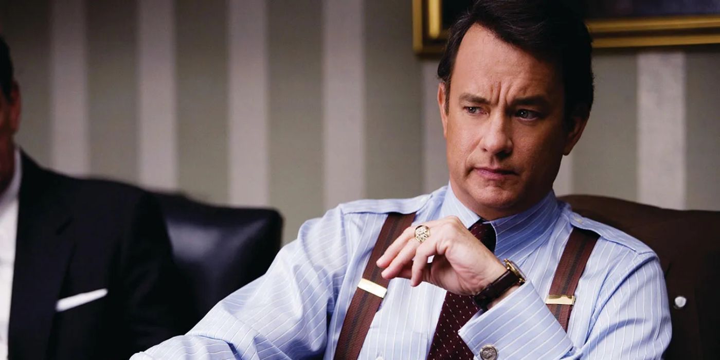 Tom Hanks as Charlie Wilson sitting at a desk in Charlie Wilson&rsquo;s War