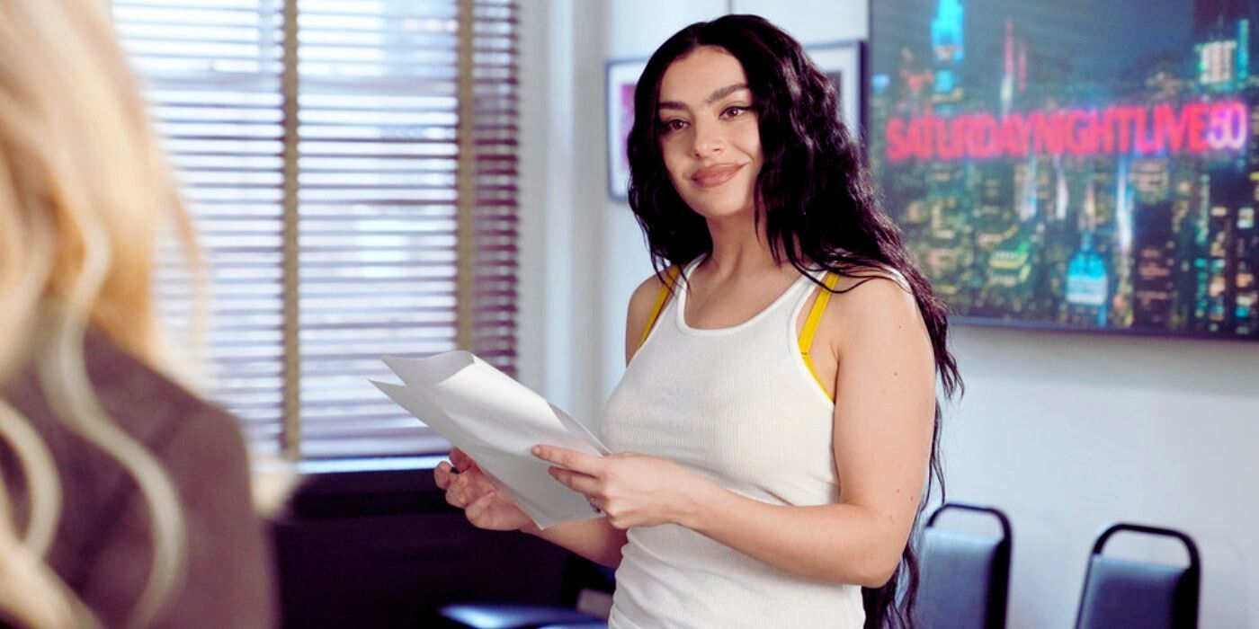 Charli XCX in a tanktop holding a script in the SNL offices.