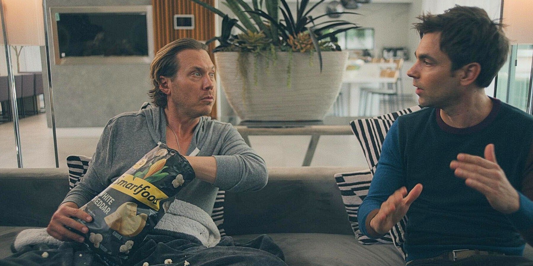 Ness and Sandy Gordon sitting on a couch together in Running Point.